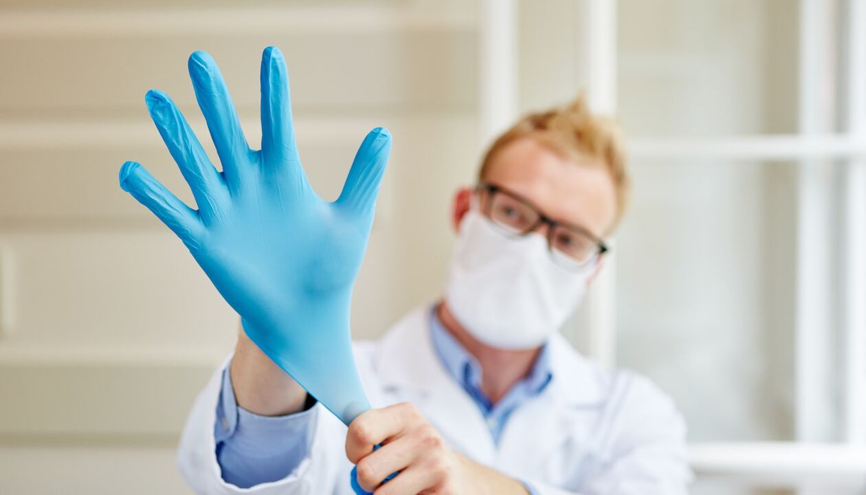 den Dokter setzt en Handschuesch op fir d'Massage fir Prostatitis ze vermeiden
